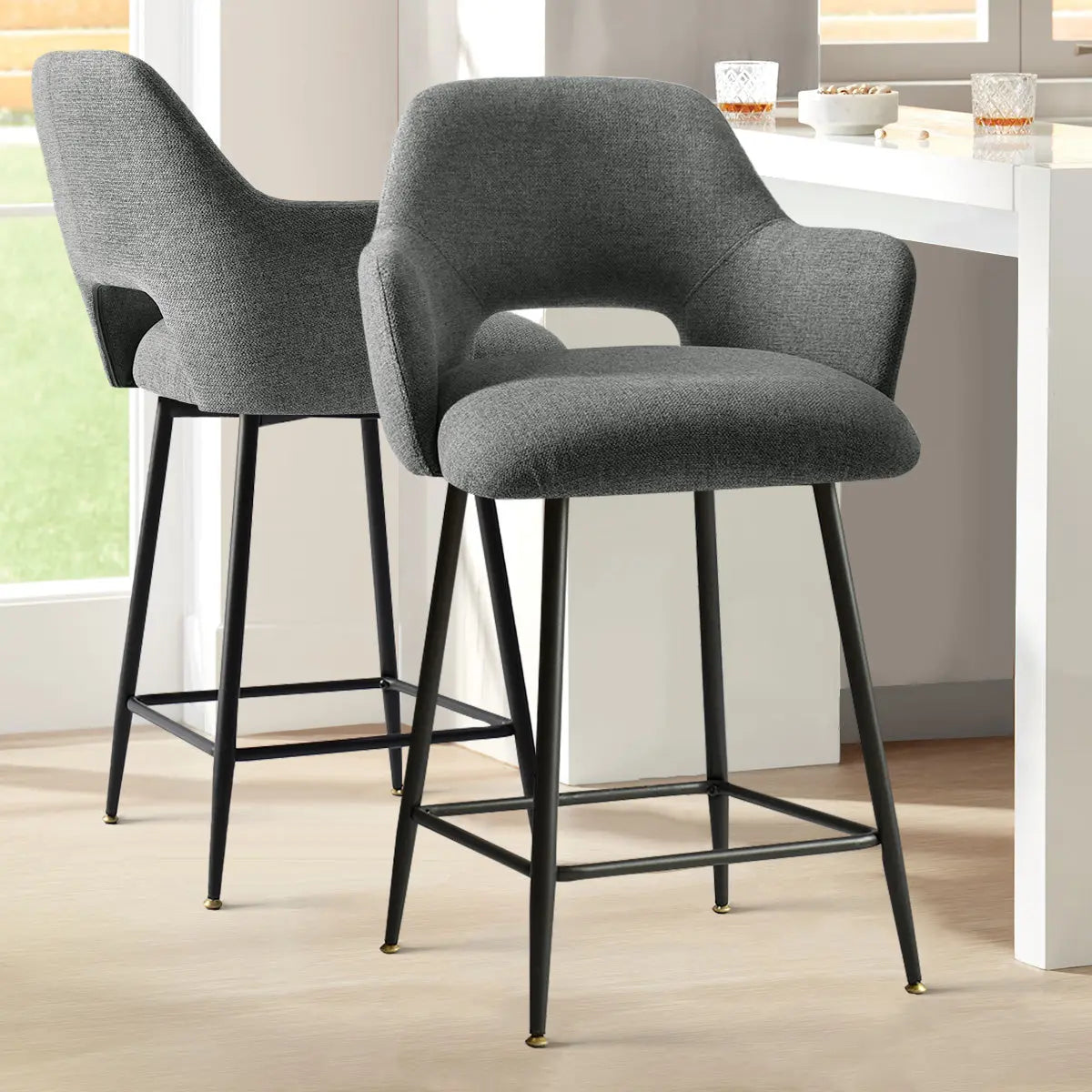 Edwin Modern Upholstered Counter Stool with Arms, grey; light wood flooring, white kitchen island setting.