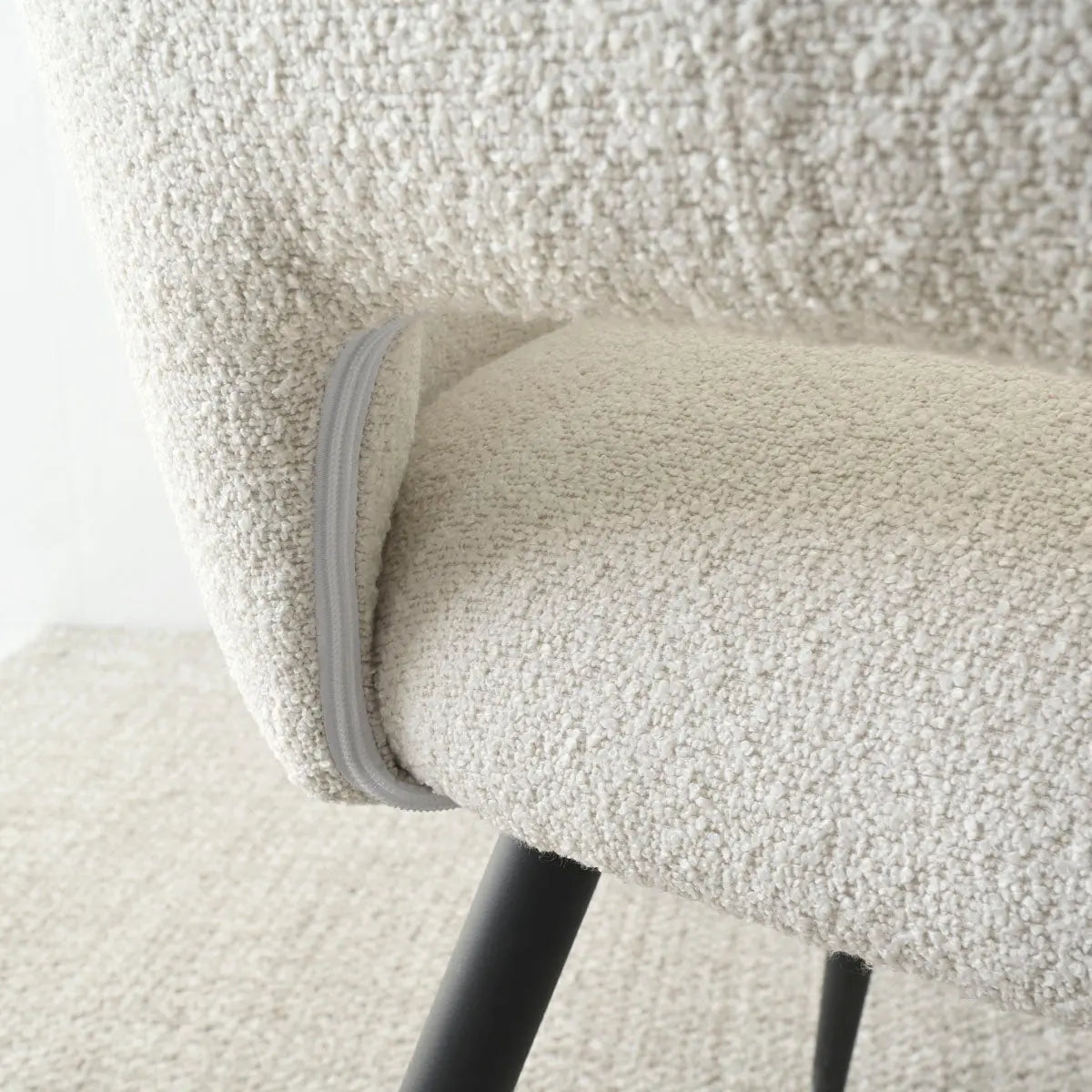 Close-up of Edwin dining chair textile and legs, featuring modern design elements and neutral upholstery.