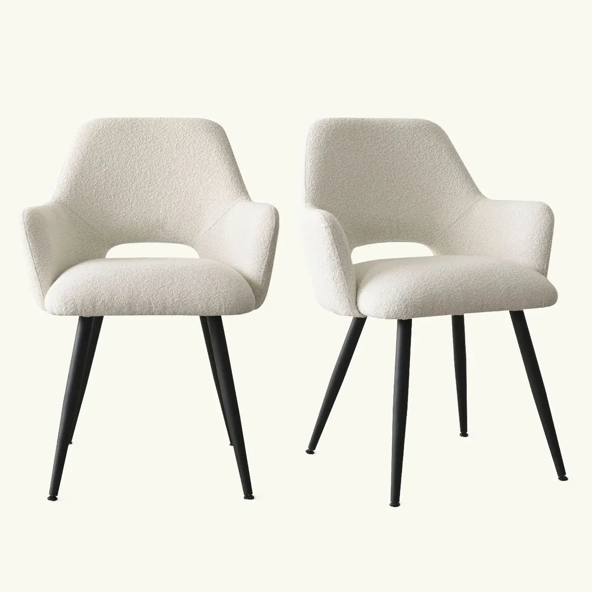 Pair of white Edwin Modern Upholstered Dining Chairs with Arms on black legs in light room.