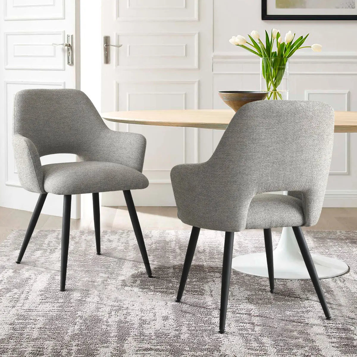 Edwin Modern Upholstered Dining Chair with Arms in elegant room, gray carpet, white walls.