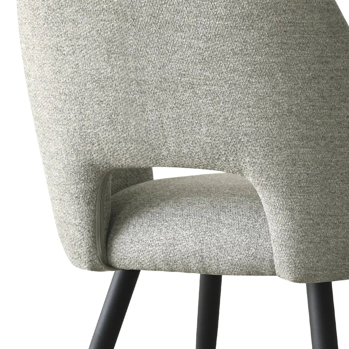 Close-up of Dwen & Edwin chair with grey upholstery and black legs, part of dining set.