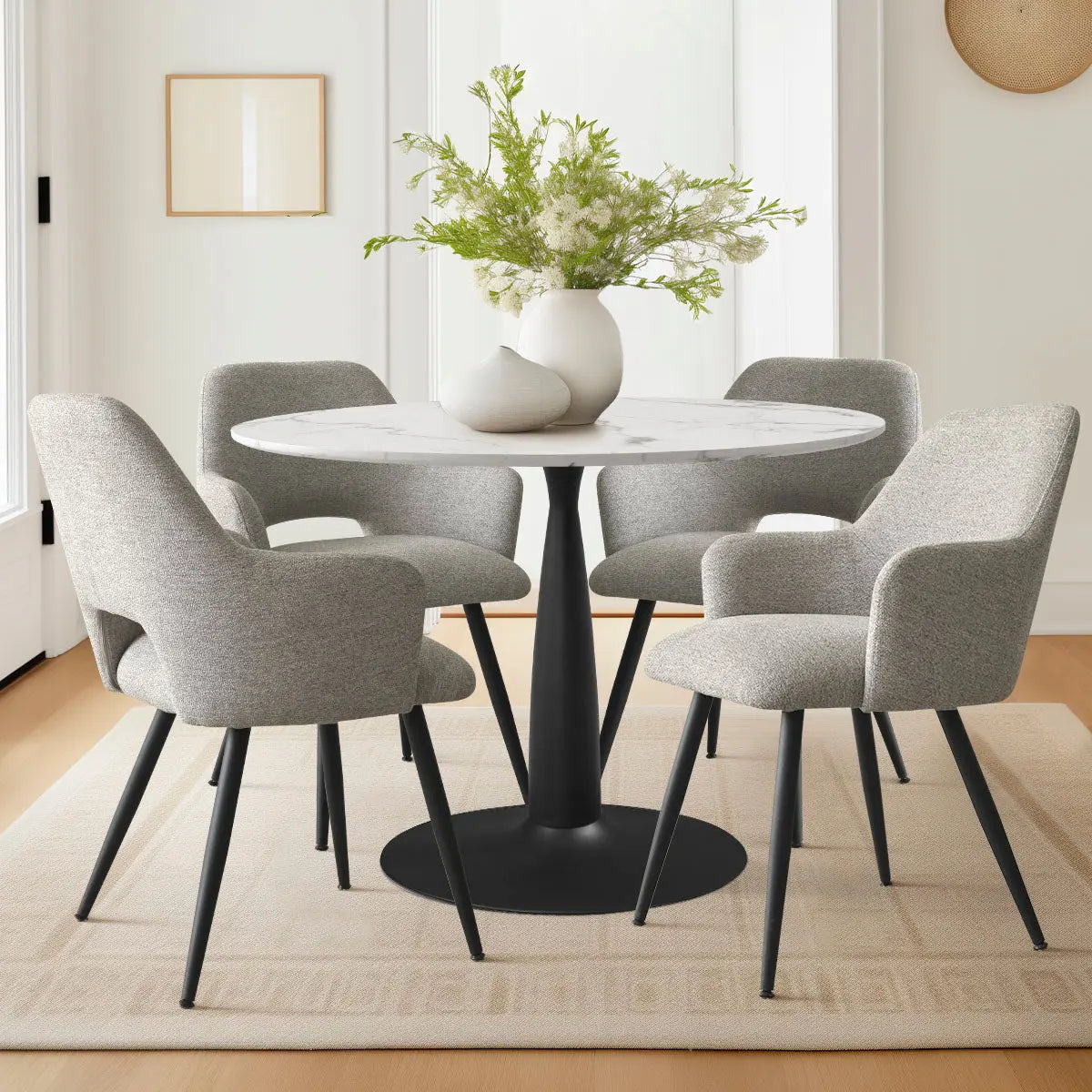 Gray Edwin dining chairs with arms around marble table in modern room, light wood flooring.