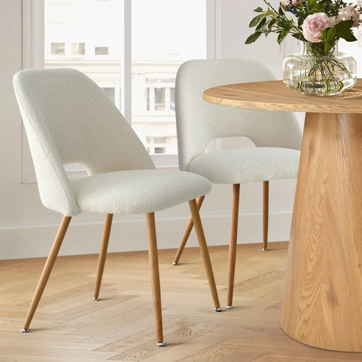 Dwen & Edwin Modern Round Dining Table Set in bright room, wooden chairs, light parquet flooring.