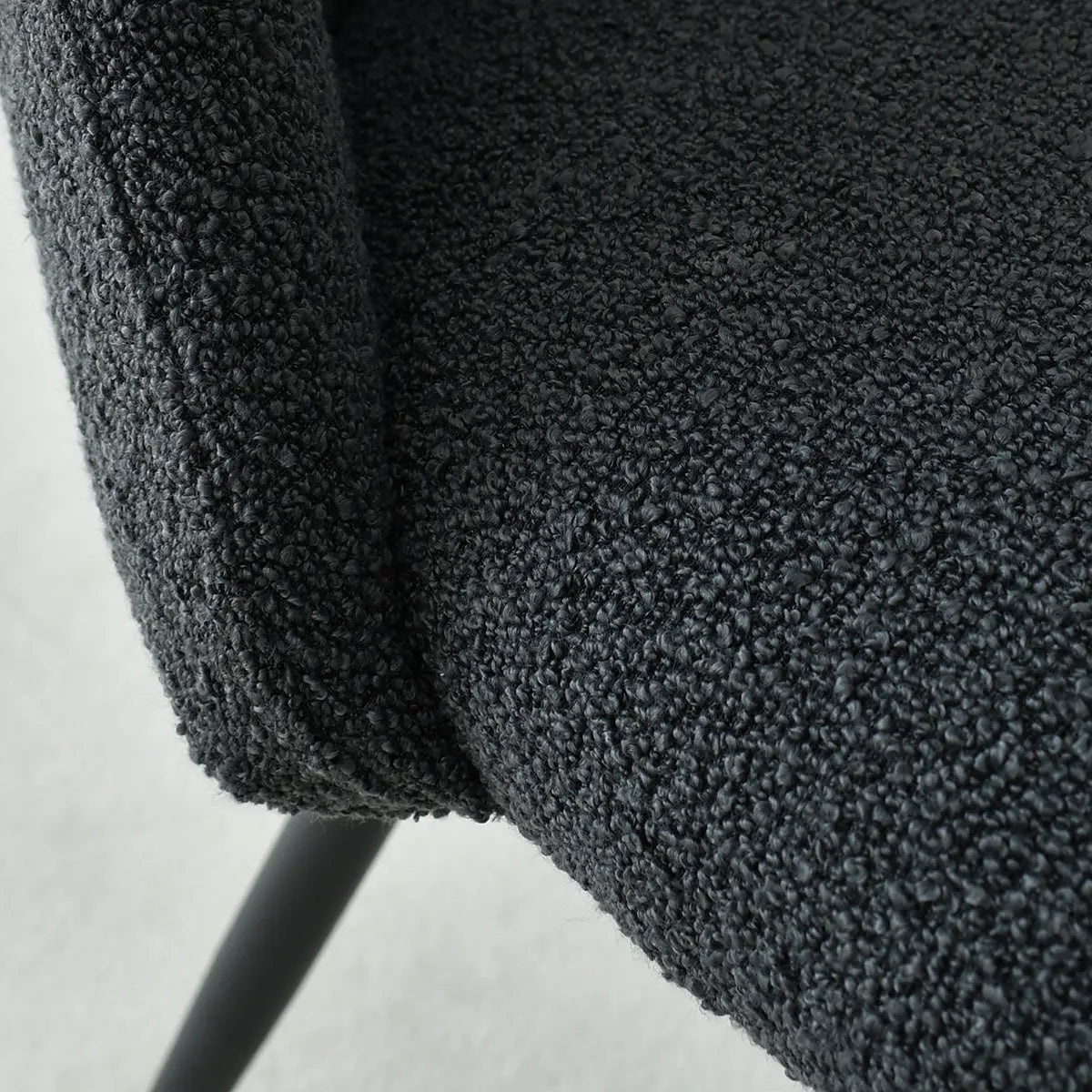 Close-up of Edwin Modern Upholstered Dining Chair texture and metal legs detail, dark fabric finish.