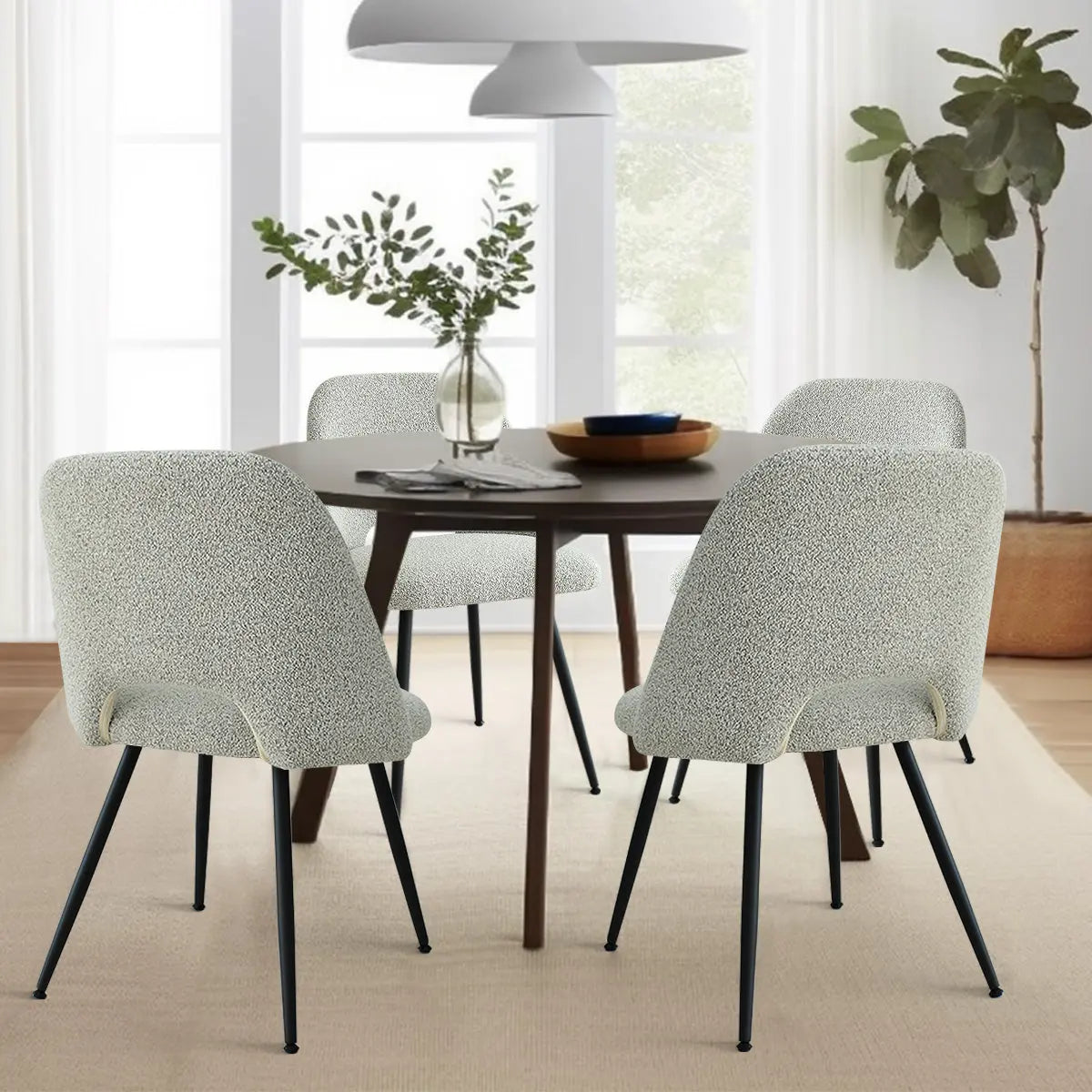 Edwin Modern Upholstered Dining Chair with black legs, round wooden table, neutral room decor.