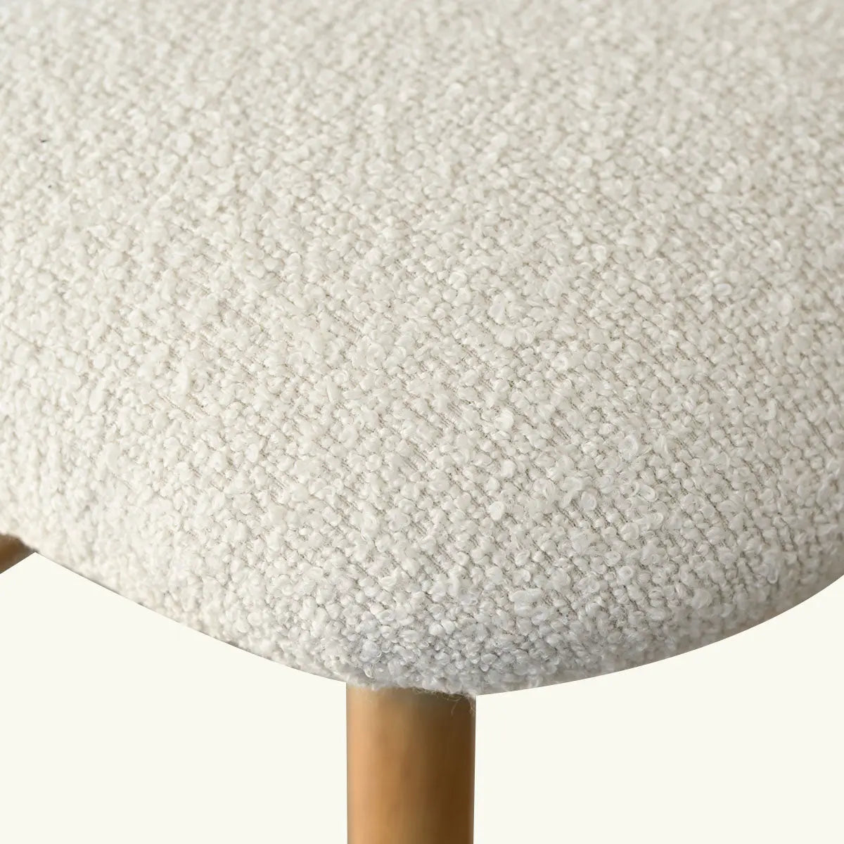 Close-up of Edwin Boucle Upholstered Counter Stool's textured seat with oak leg.