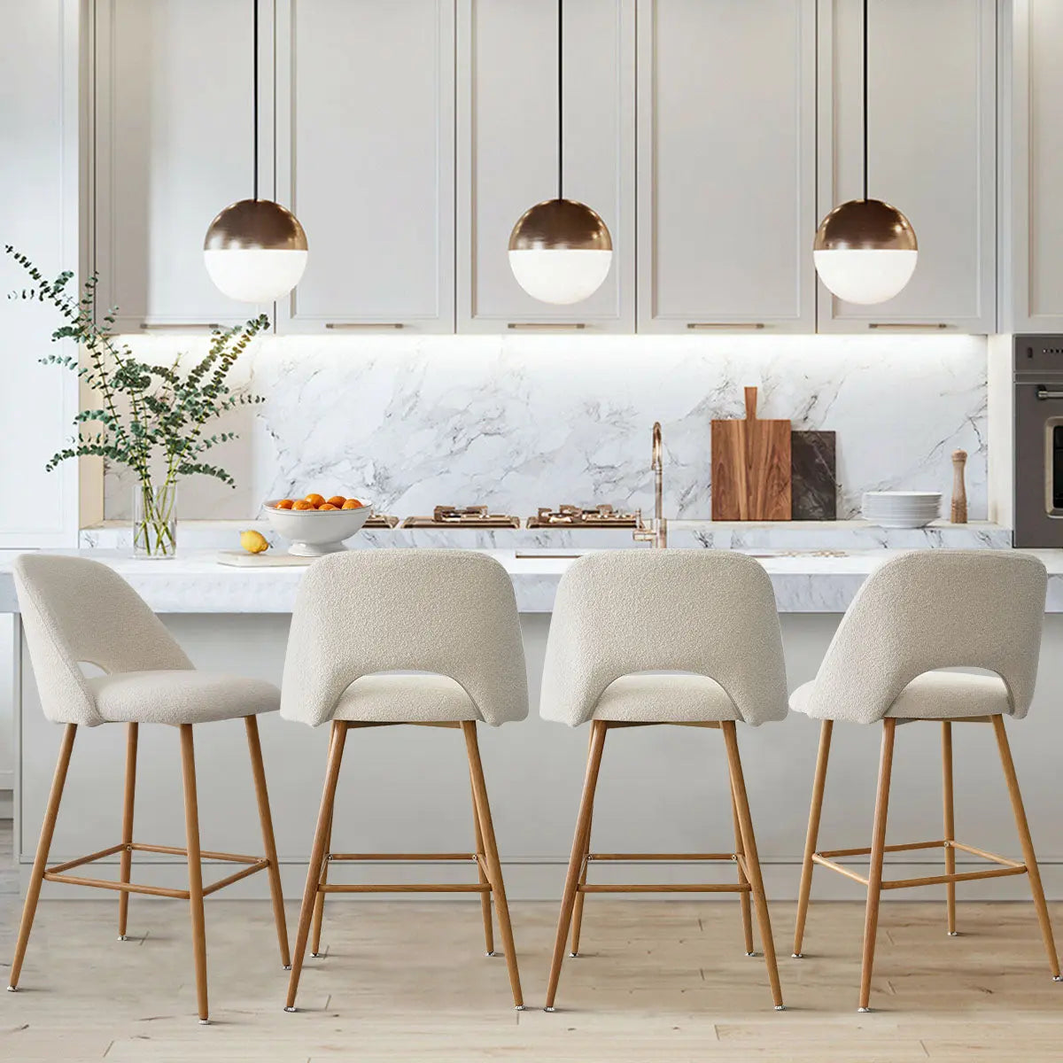 Edwin Boucle Counter Stool with Oak Legs in modern kitchen with marble backsplash, white cabinetry.