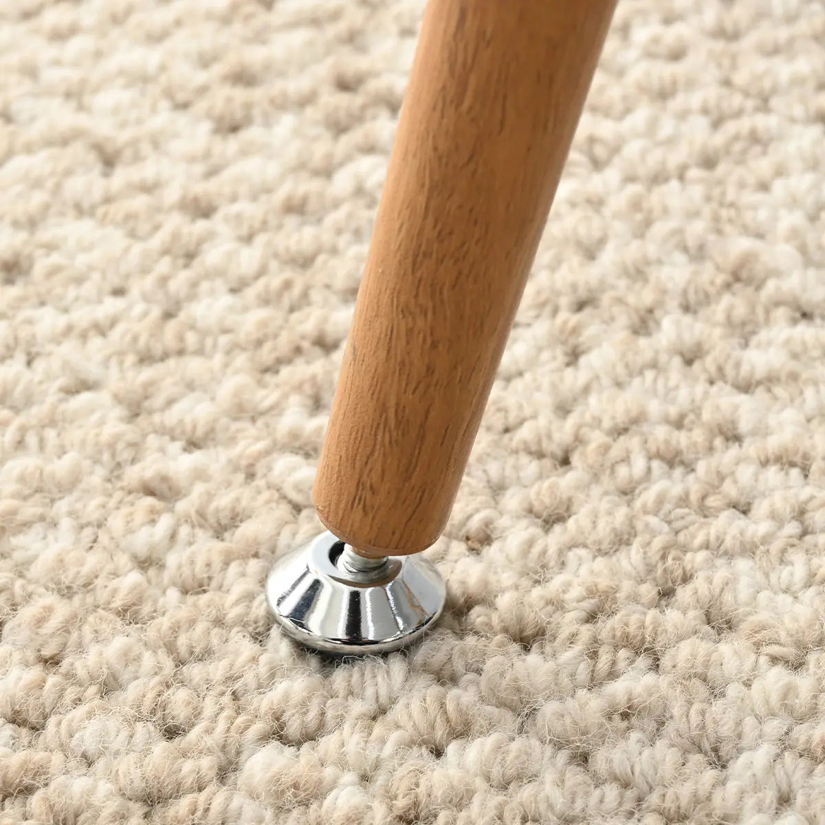 Edwin Modern Boucle Upholstered Counter Stool leg on textured beige carpet in a cozy setting.