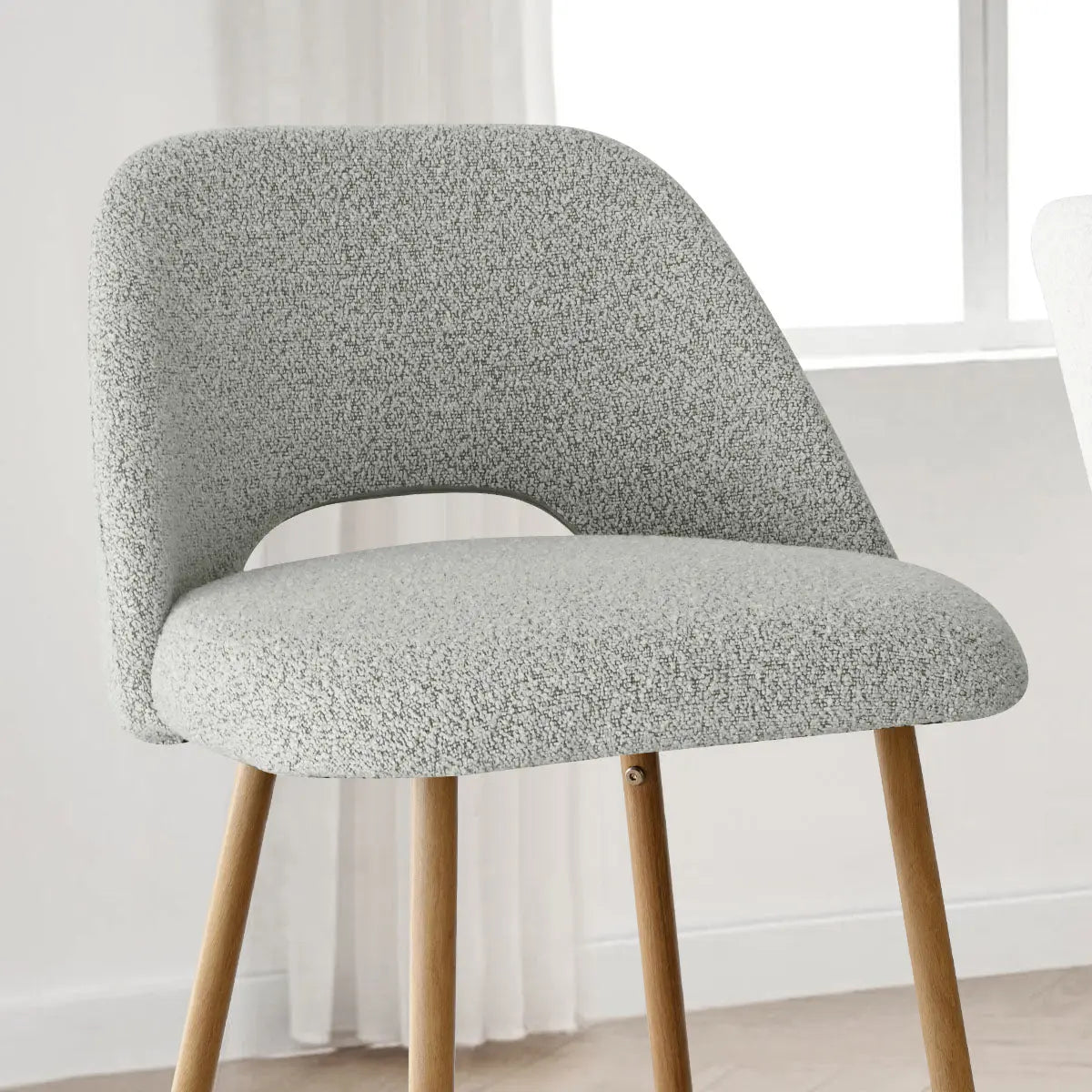 Edwin Modern Boucle Counter Stool with oak legs in minimalist room, neutral wall, wood flooring.