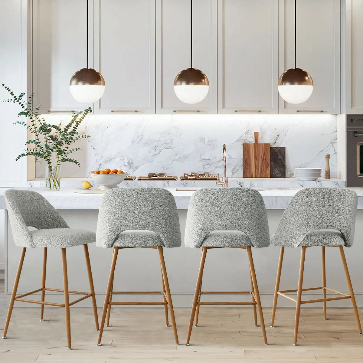 Edwin Modern Boucle Counter Stool in kitchen with marble backsplash, pendant lights, and oak flooring.