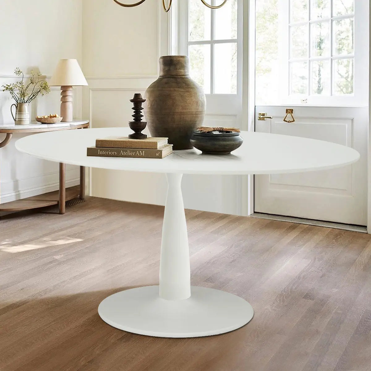 Harris white oval dining table with light wood flooring, neutral walls, and elegant decor elements.