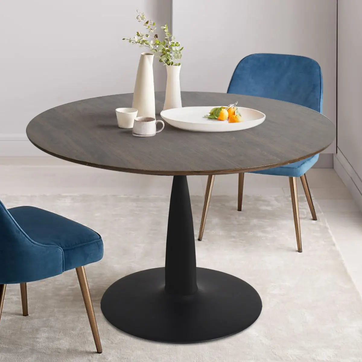 Harold 40'' round pedestal dining table, modern design; blue velvet chairs on light carpet flooring.