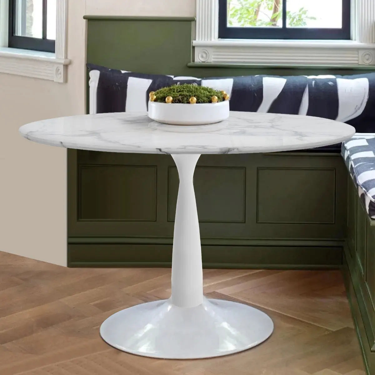 Harris marble pedestal dining table in kitchen with green bench, herringbone floor, and window view.