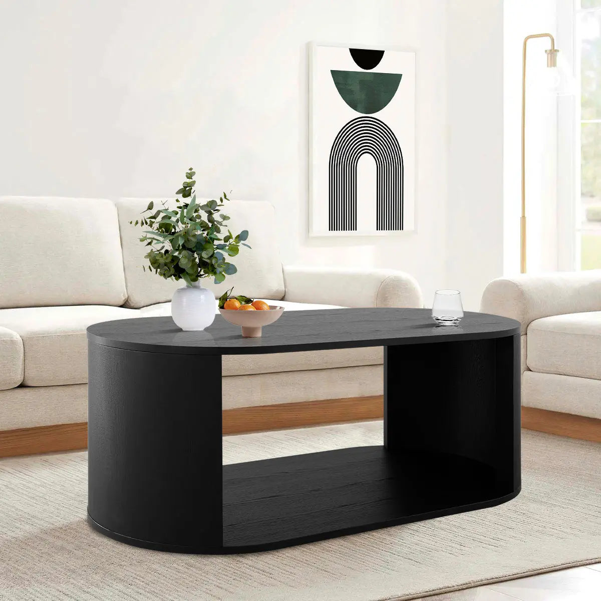 Hobo Modern Black Oval Coffee Table in beige sofa living room, abstract art, white wall.