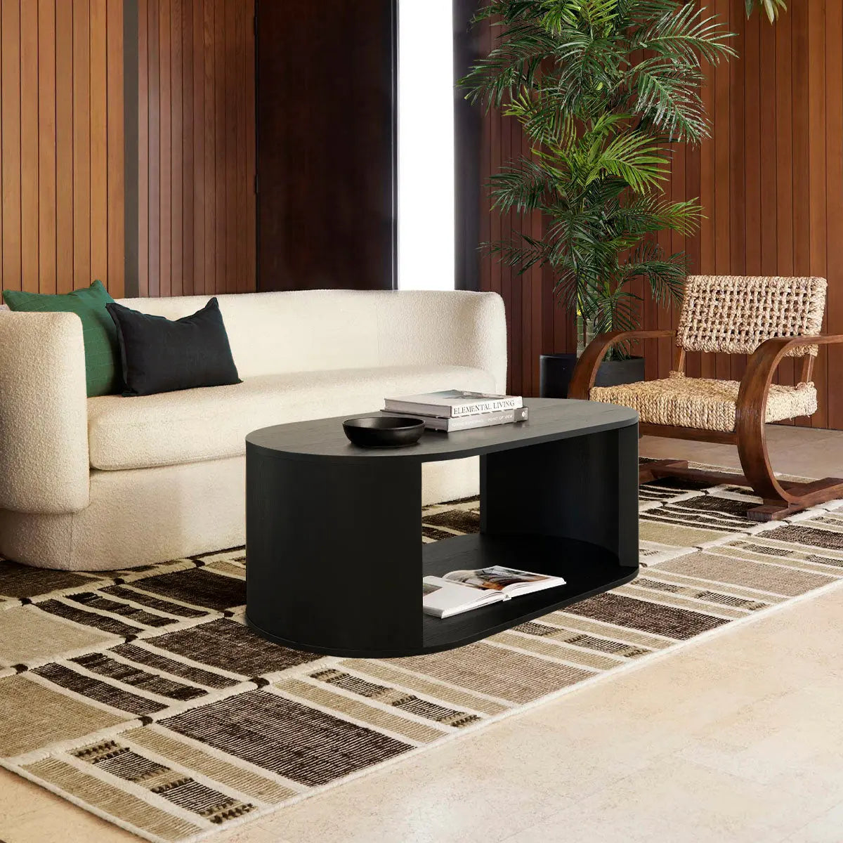 Hobo Modern Black Oval Coffee Table in stylish living room with beige sofa and wooden walls.