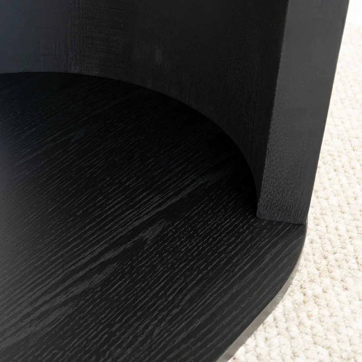 Close-up of Hobo Modern Black Oval Coffee Table with textured black finish on beige carpet.