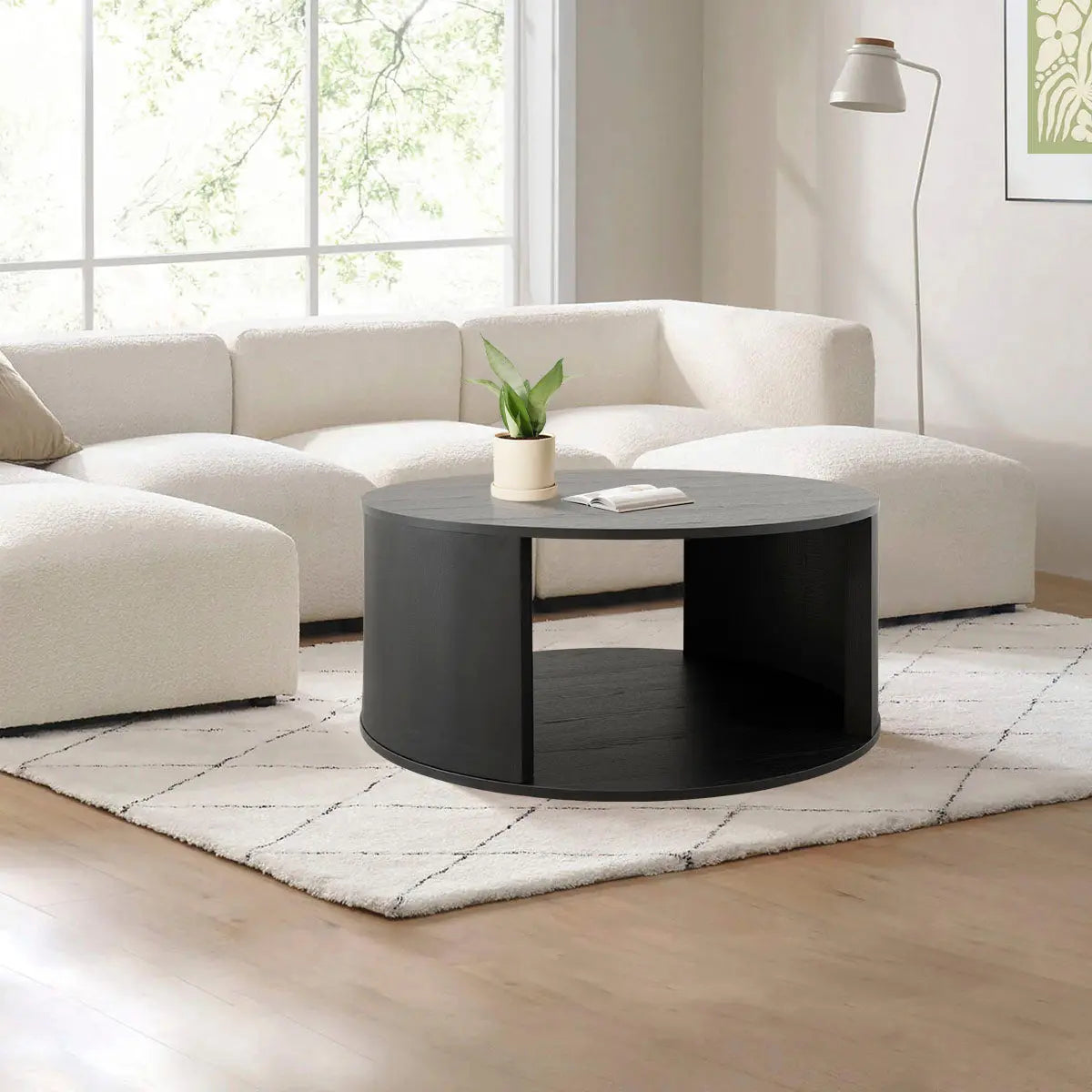 Hobo Modern Black Round Coffee Table in living room with white sofa and light wood flooring.