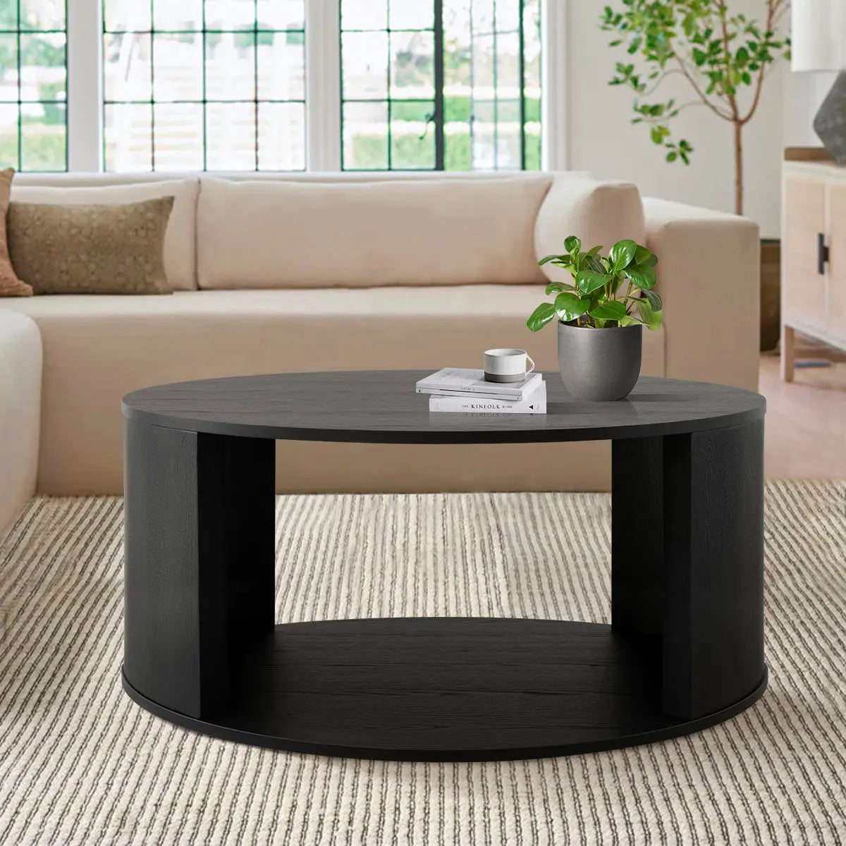 Hobo Modern Black Round Coffee Table in cozy living room with cream sofa and patterned carpet.