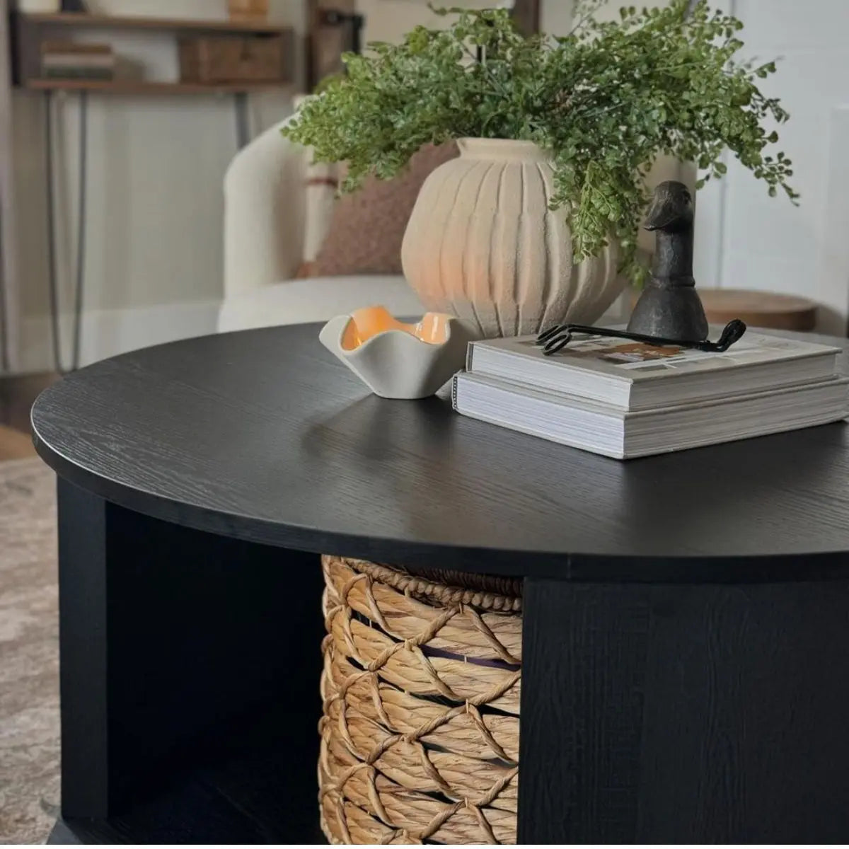 Hobo Modern Black Round Coffee Table in living room with beige sofa and woven basket detail.