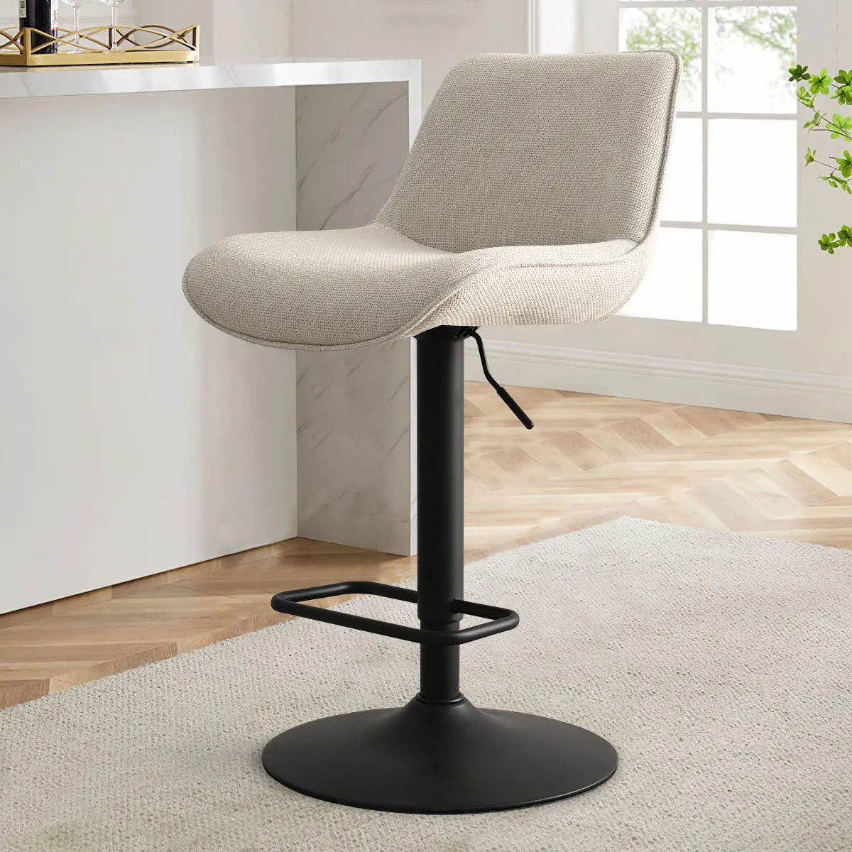 Hunter Modern Upholstered Swivel Adjustable Stool in beige; marble countertop; hardwood floors; neutral decor.