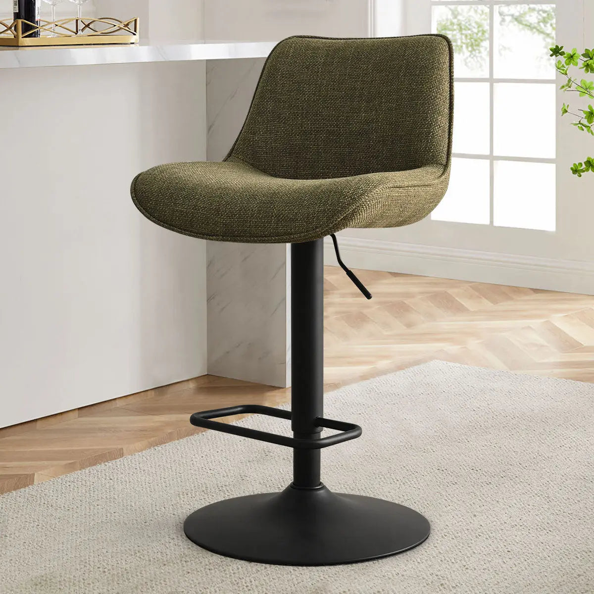 Hunter Modern Upholstered Swivel Counter Stool, green seat, marble counter, parquet flooring, bright room.