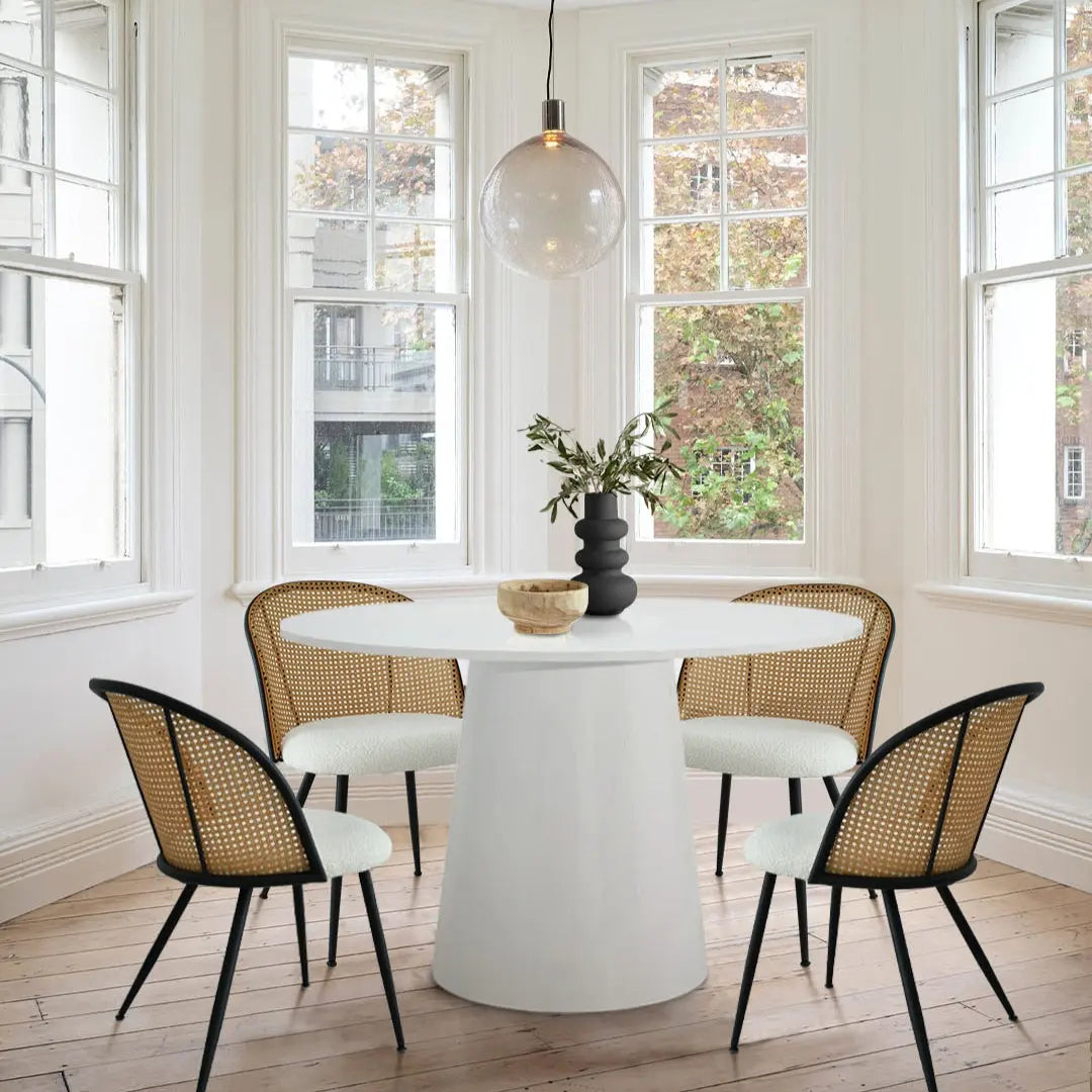 Jules dining chairs around white table, wooden floor, white walls, in bright and airy dining room.