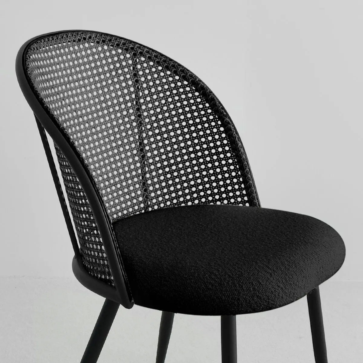 Jules Modern Upholstered Rattan Dining Chair, black design, minimal setting, curved backrest.