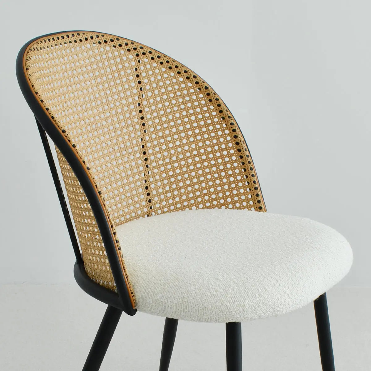 Jules upholstered rattan dining chair in a neutral room with modern design elements.