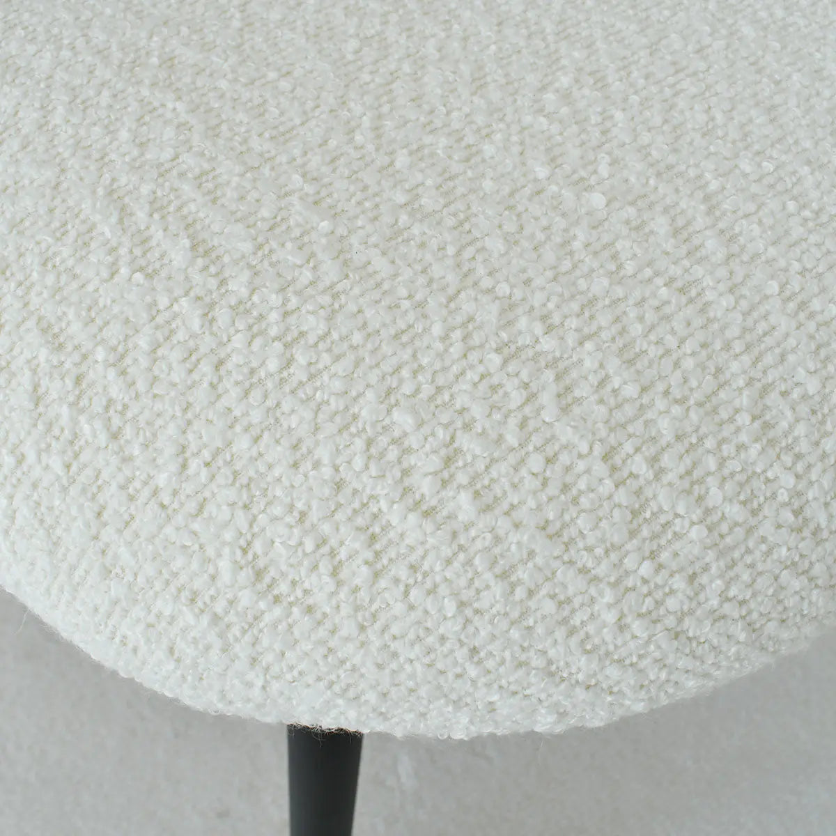 Close-up of upholstered seat texture on Jules Modern Rattan Counter Stool with metal legs.