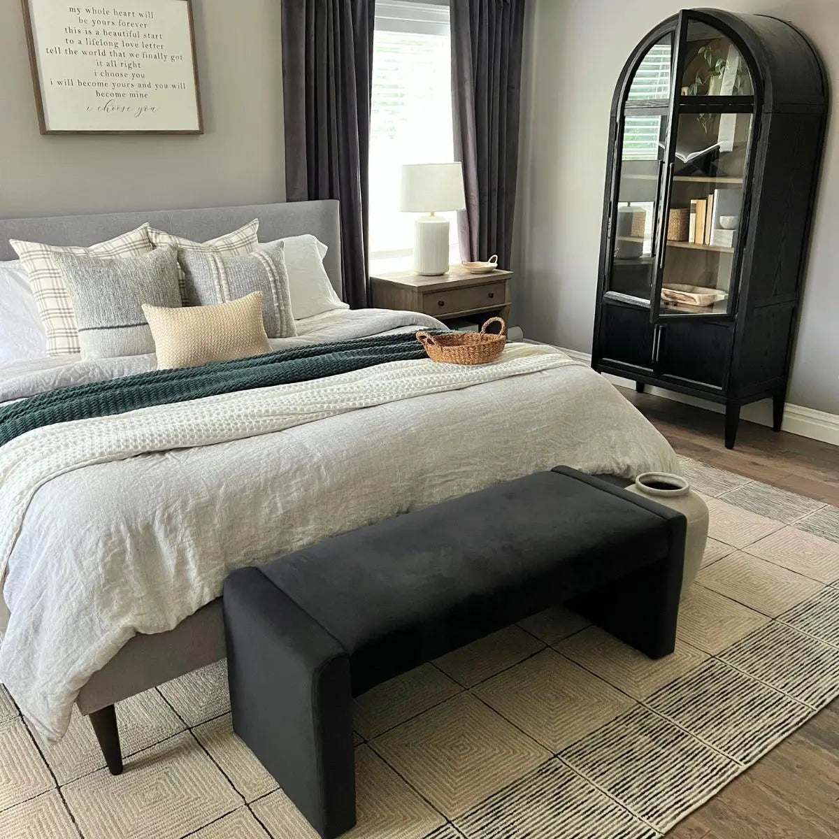 Kaia Modern Leather & Velvet Waterfall Bench in bedroom with grey walls, wooden flooring, and cabinet.