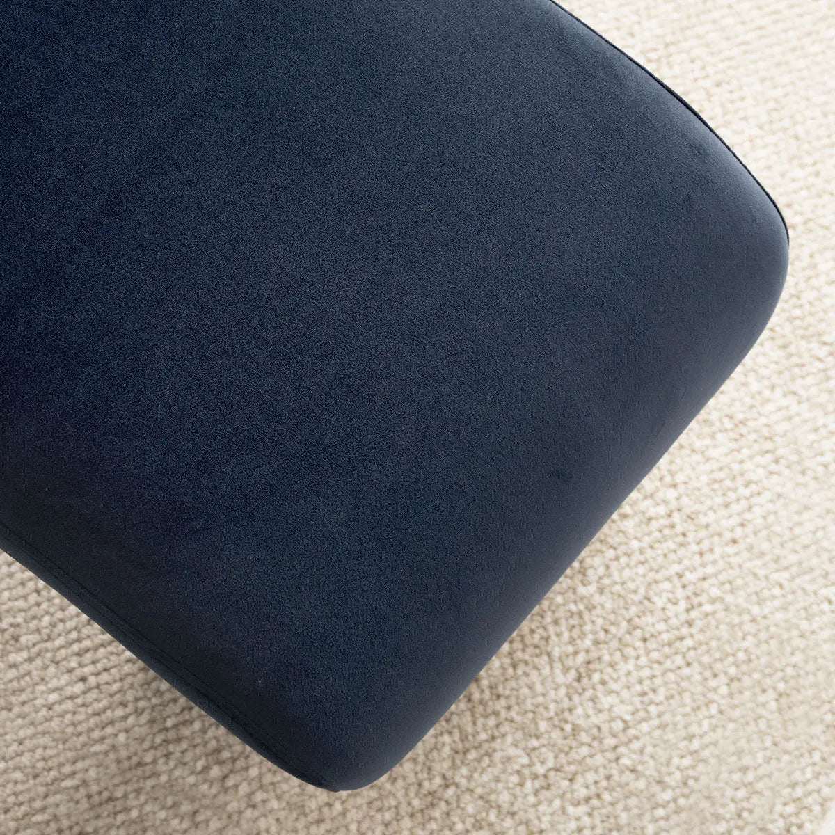 Lily Modern Velvet Waterfall Bench in navy on light carpet, featuring elegant minimalist design.