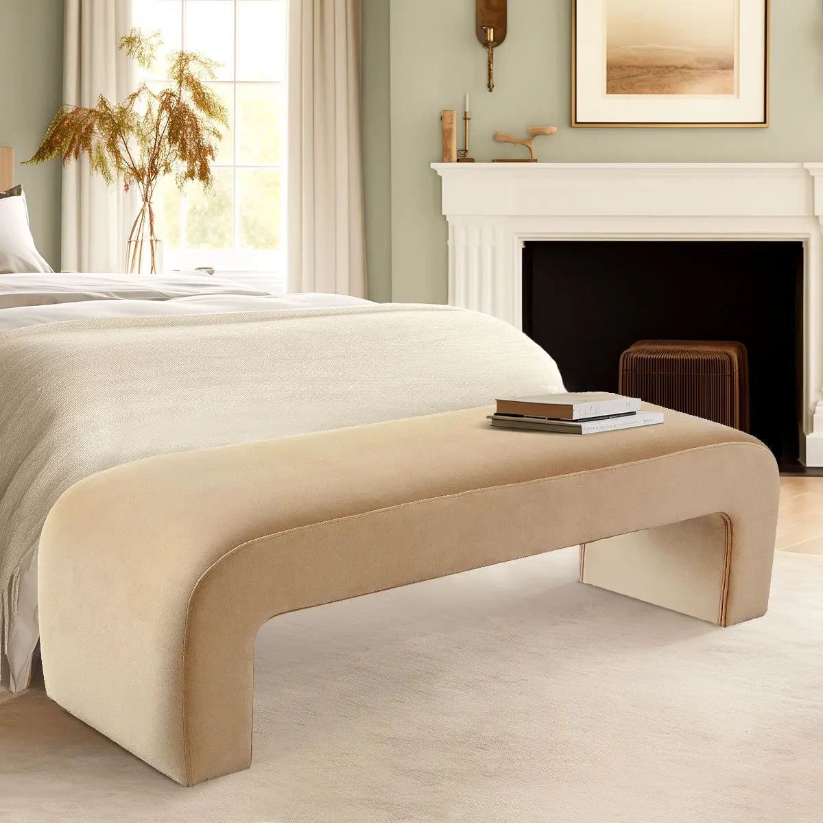 Cream velvet waterfall bench in elegant bedroom with white fireplace and soft green walls.