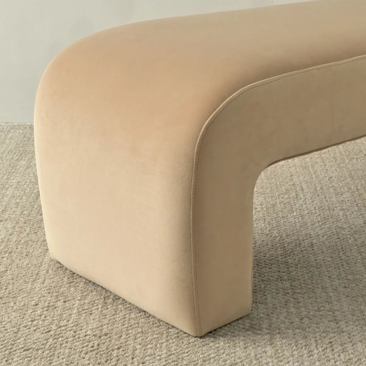 Cream-colored Lily Modern Velvet Accent Waterfall Bench on textured carpet in minimalist room setting.