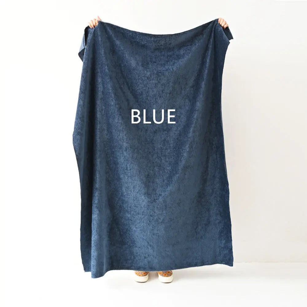 Blue fabric held by person, chenille texture, indoor setting with light wall and colorful shoes visible.