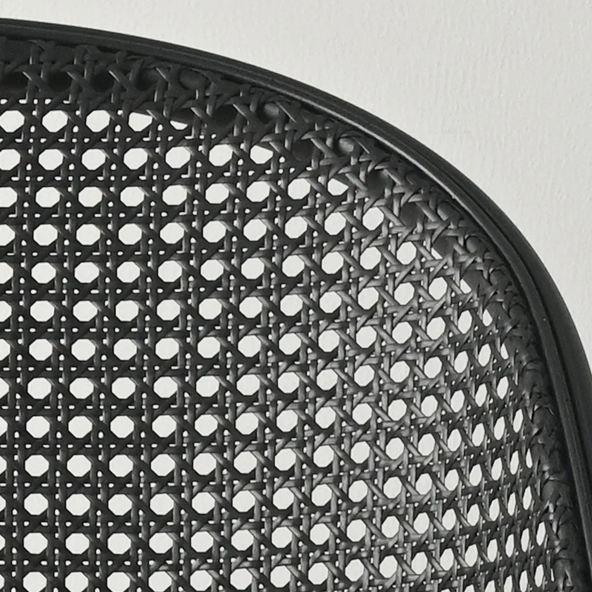 Close-up of Lucca Black Rattan Boucle Dining Chair with detailed weaving pattern on backrest.