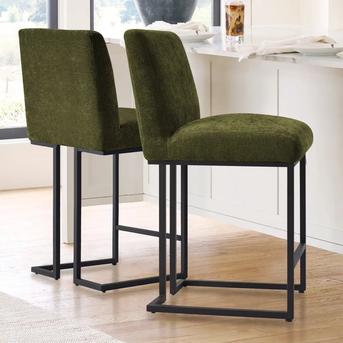 Green upholstered Mason metal frame counter stools; white kitchen, wood flooring, modern decor elements.