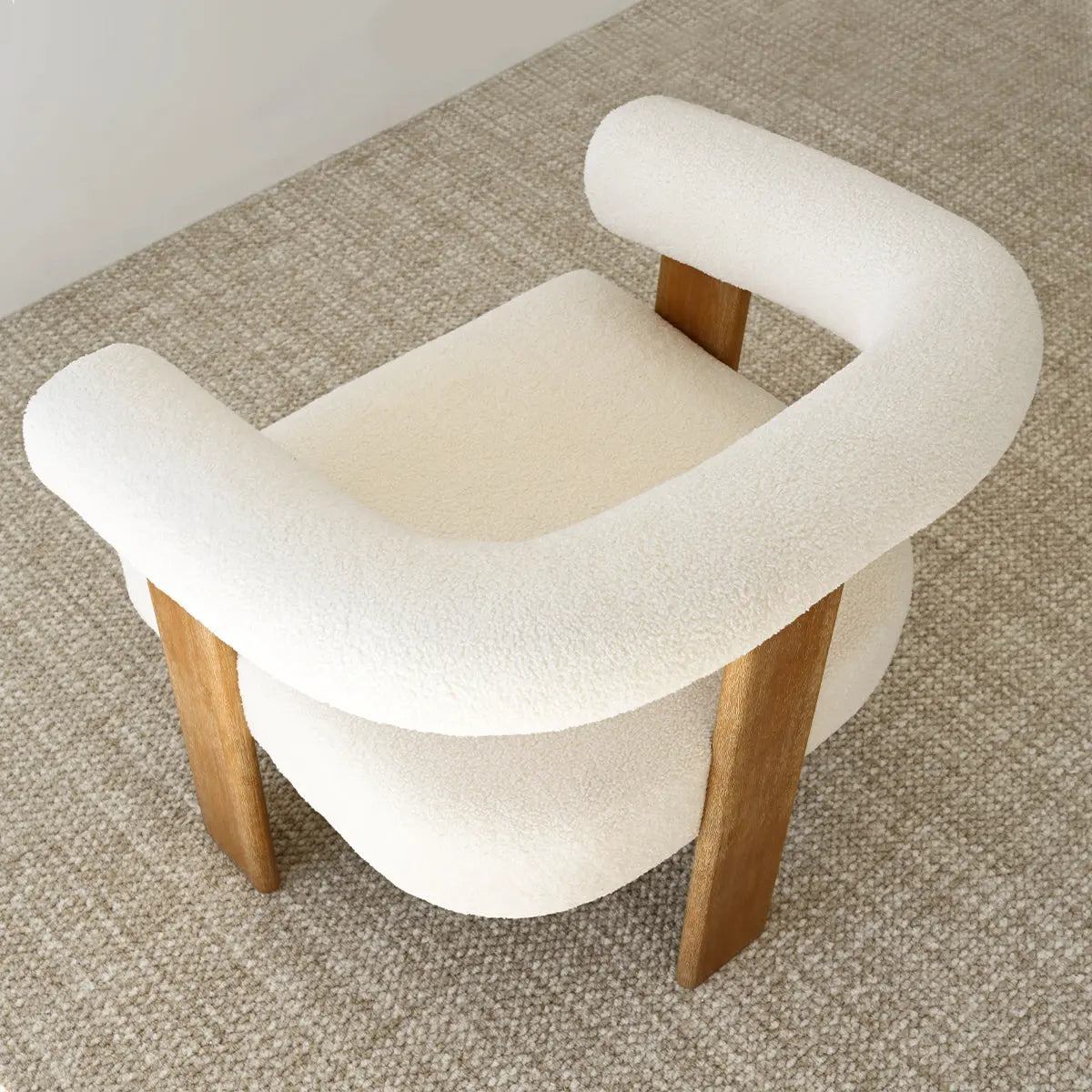 Maye Beige Boucle Chair on textured carpet, wooden legs, neutral wall, living room setting.