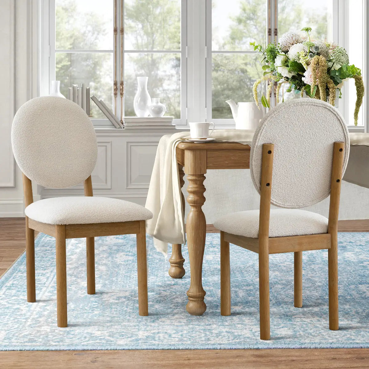 Maye Boucle Beige Dining Chair in elegant room with wooden table, blue rug, and wood flooring.