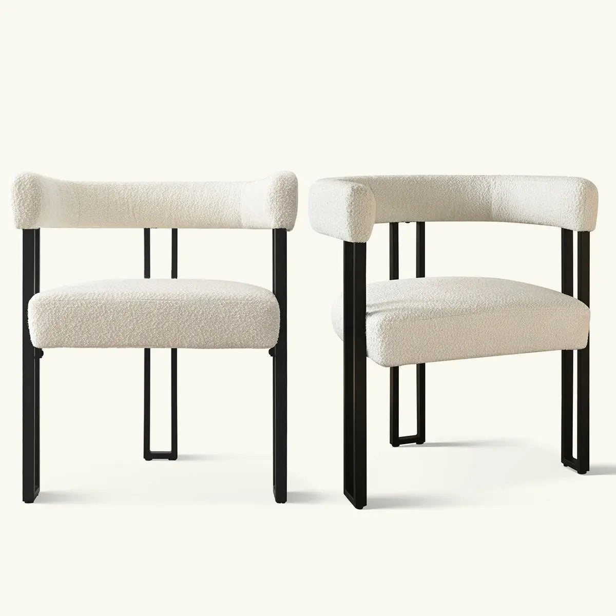 Set of two Mia beige upholstered chairs with curved backs and arms, black legs, light room.