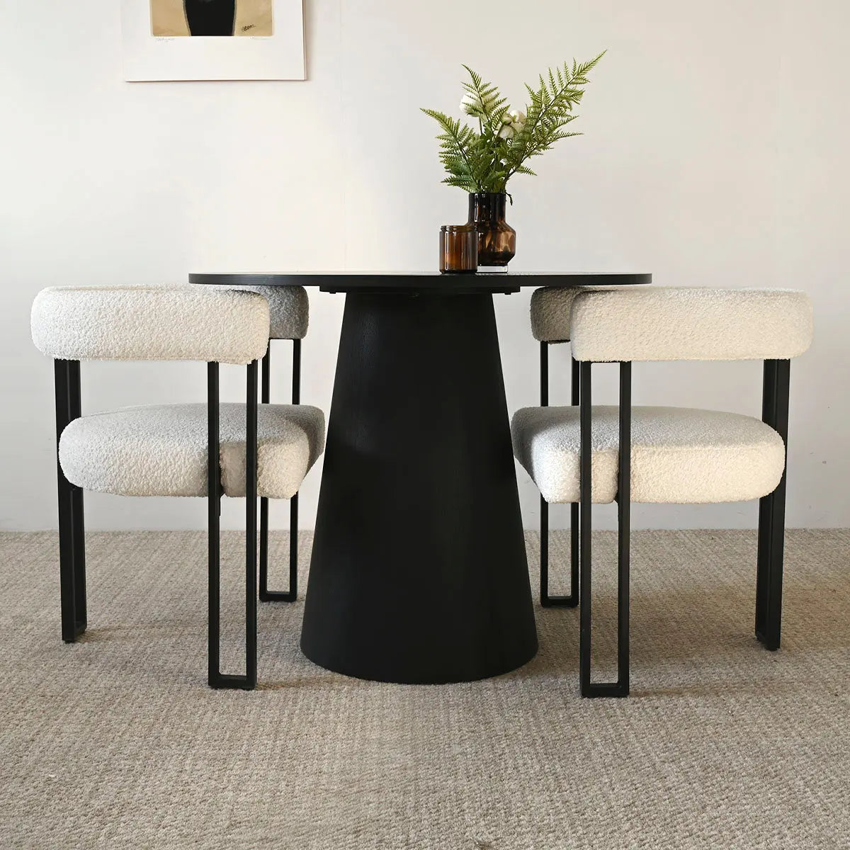 Beige upholstered dining chairs with arms, black table, neutral rug, and simple wall art.