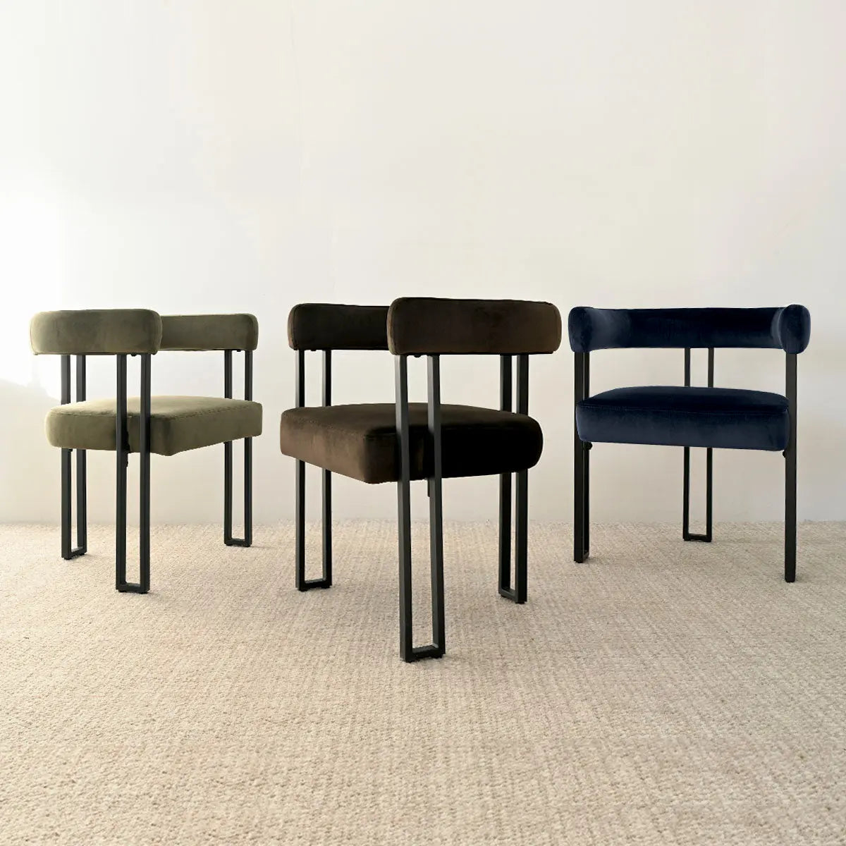 Three Mia Velvet Accent Dining Chairs with black legs on beige carpet in minimal dining room.