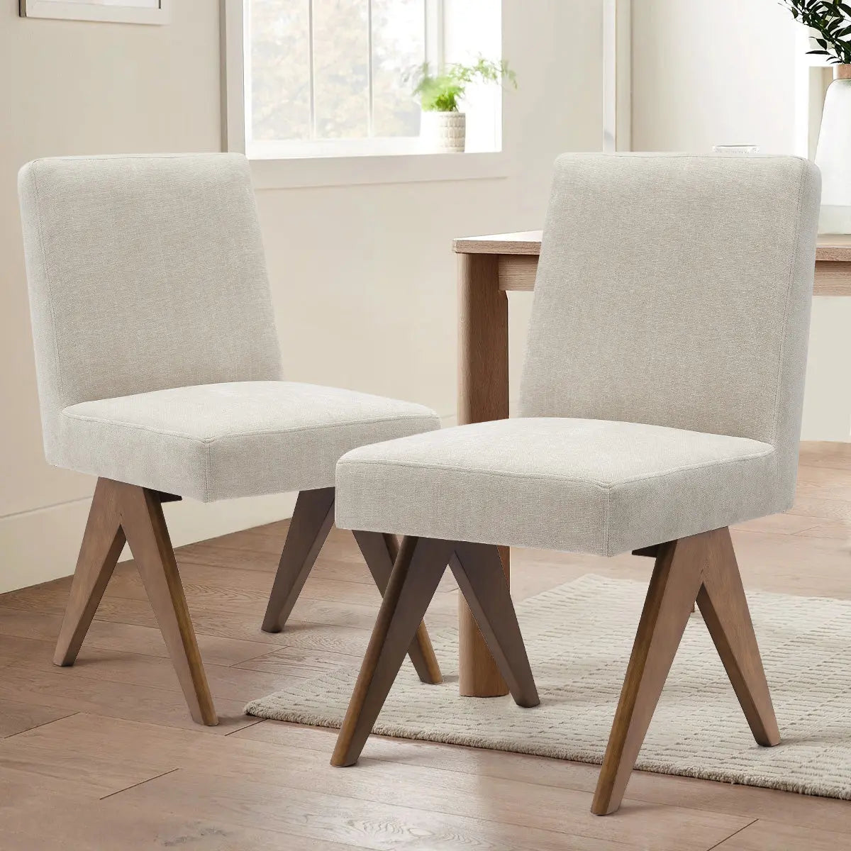 Two Morgan Mid Century Modern Upholstered Dining Chairs in a cozy dining room with wood flooring.