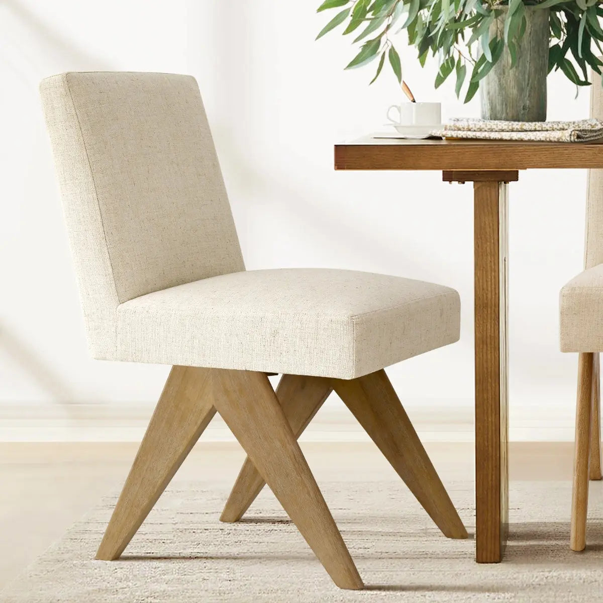 Morgan Mid-Century Boucle Upholstered Dining Chair with wood legs, beige rug, wooden dining table.