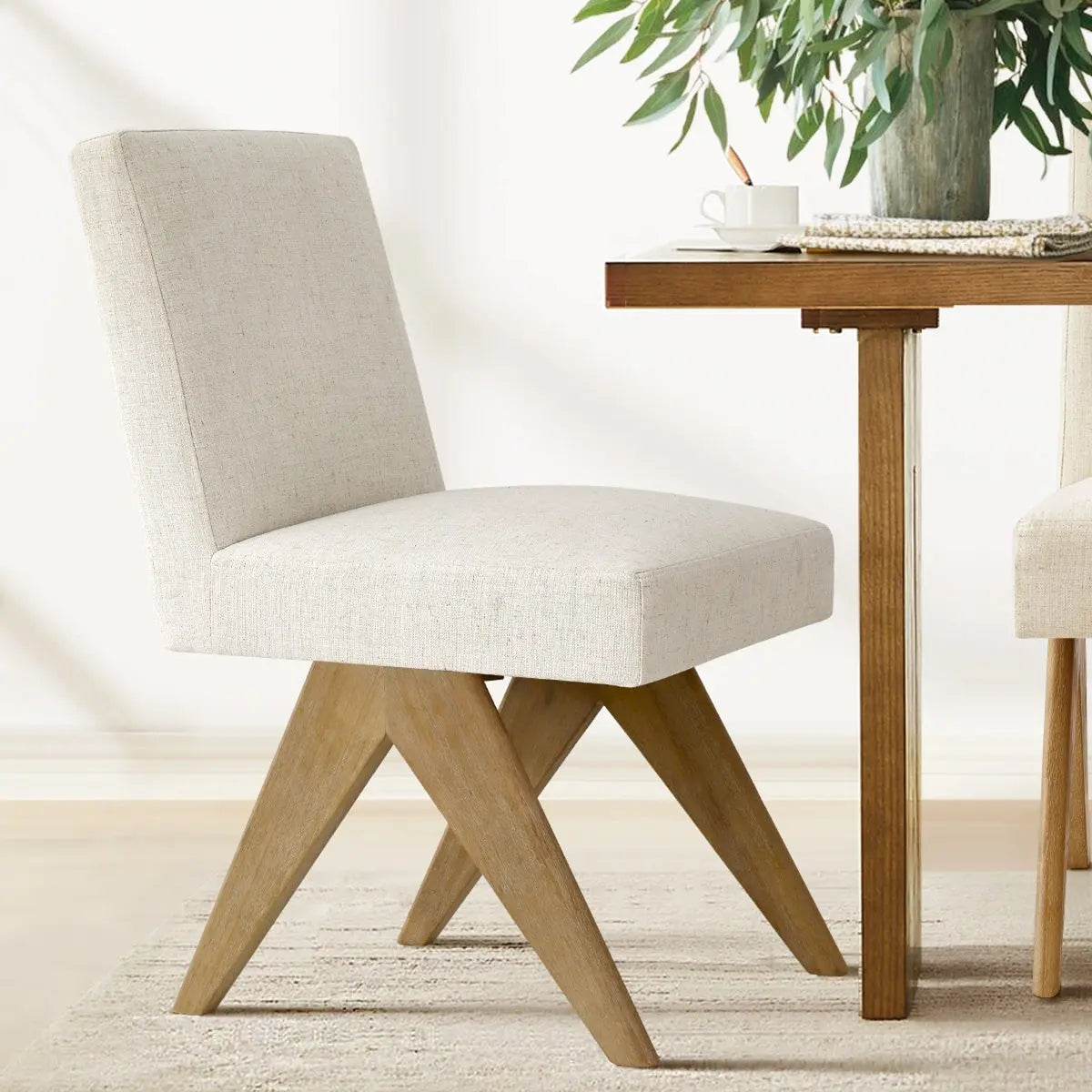 Morgan Mid-Century Boucle Upholstered Dining Chair, wooden legs, beige rug, in dining room.