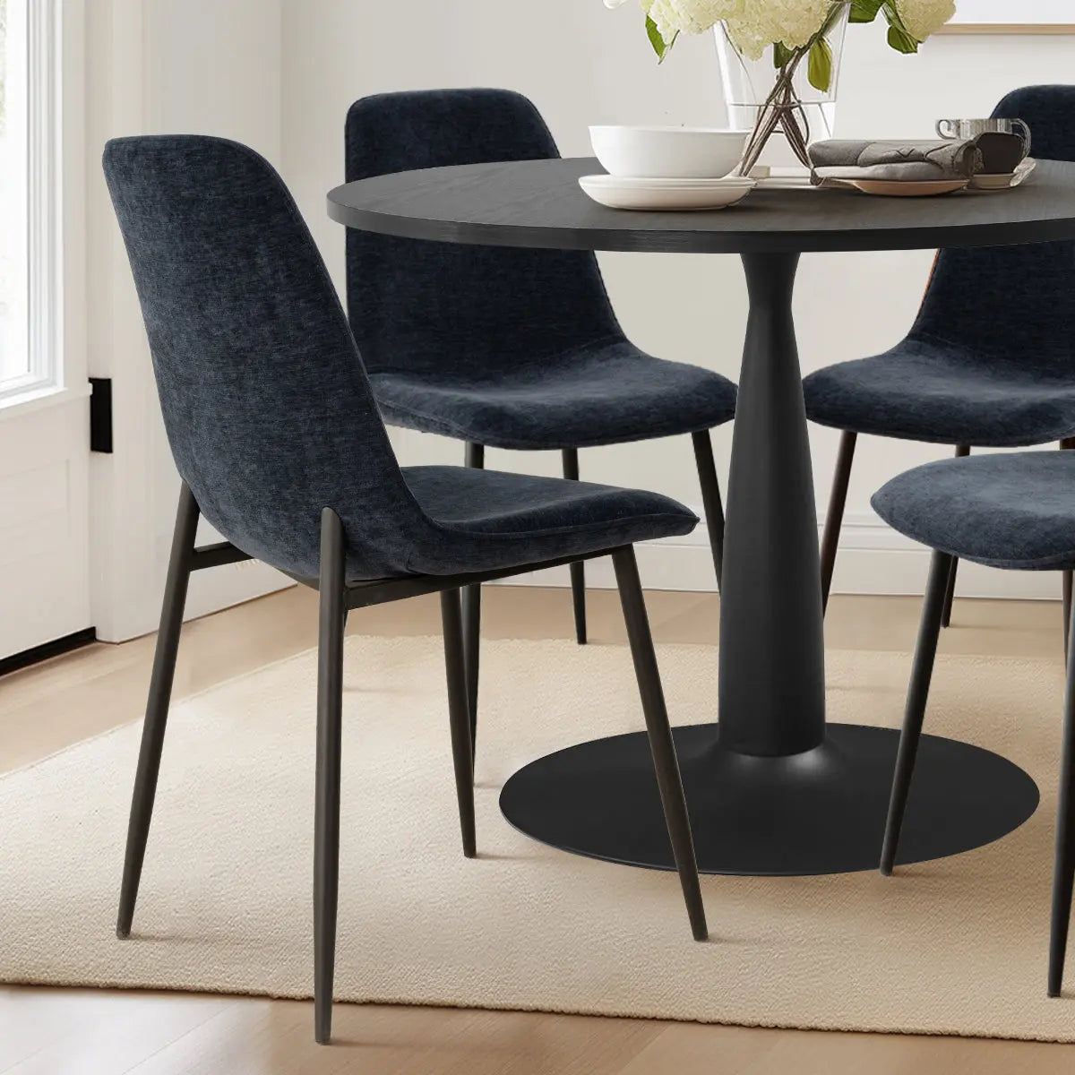 Haven & Oslo Black Table Set in modern dining room with light wood flooring and dark chairs.