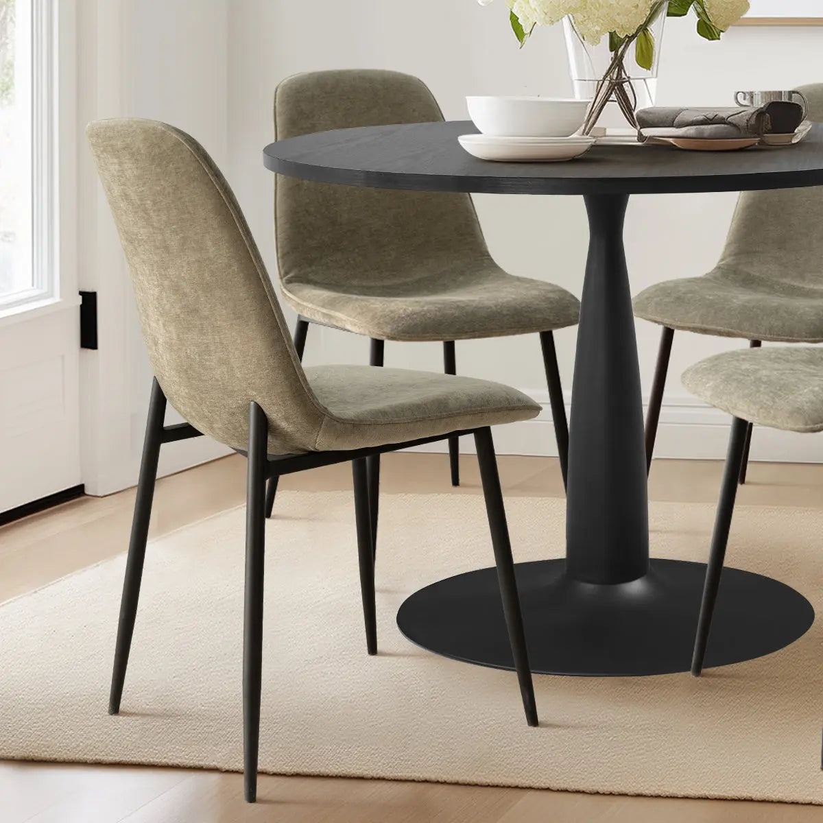 Haven & Oslo Black Round Dining Table Set with beige chairs on light wood floor in dining room.