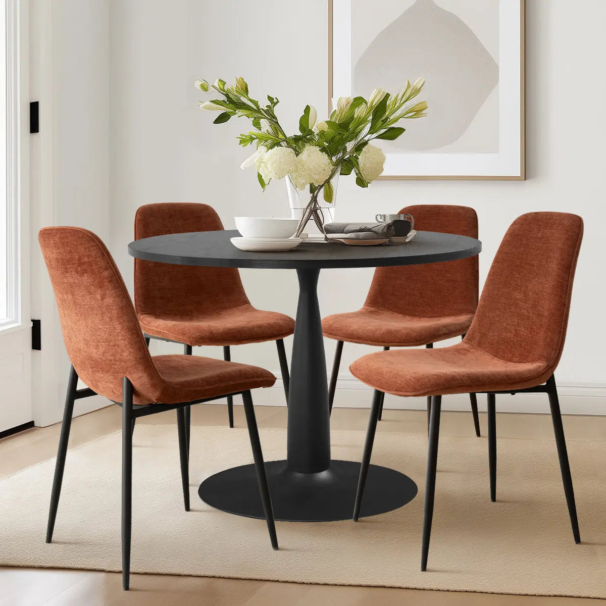 Haven & Oslo dining set with black table, four brown chairs, beige walls, wooden floor, rug.