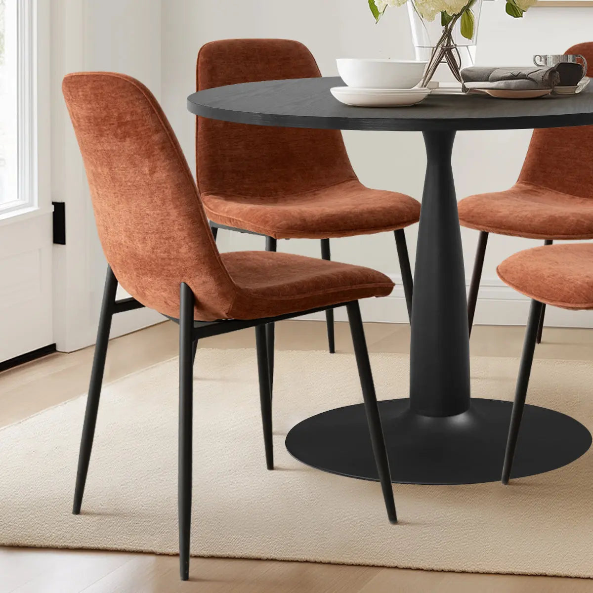 Haven & Oslo Black Round Dining Table Set with brown chairs, light wood flooring in dining room.