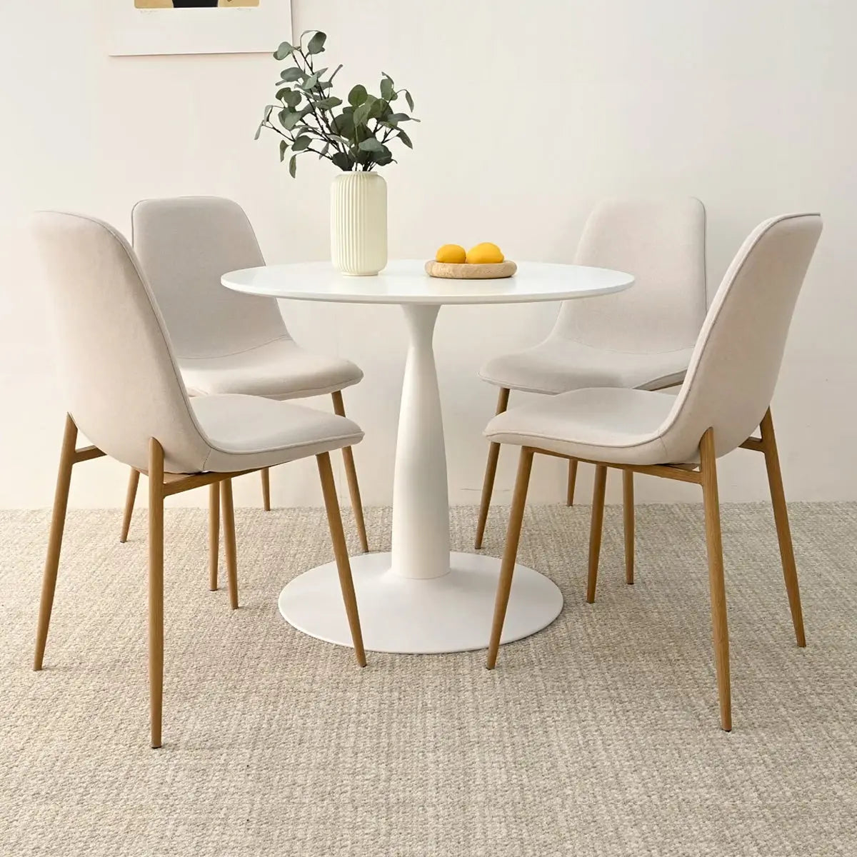 Haven & Oslo round dining table set with beige chairs on carpeted floor in modern dining room.