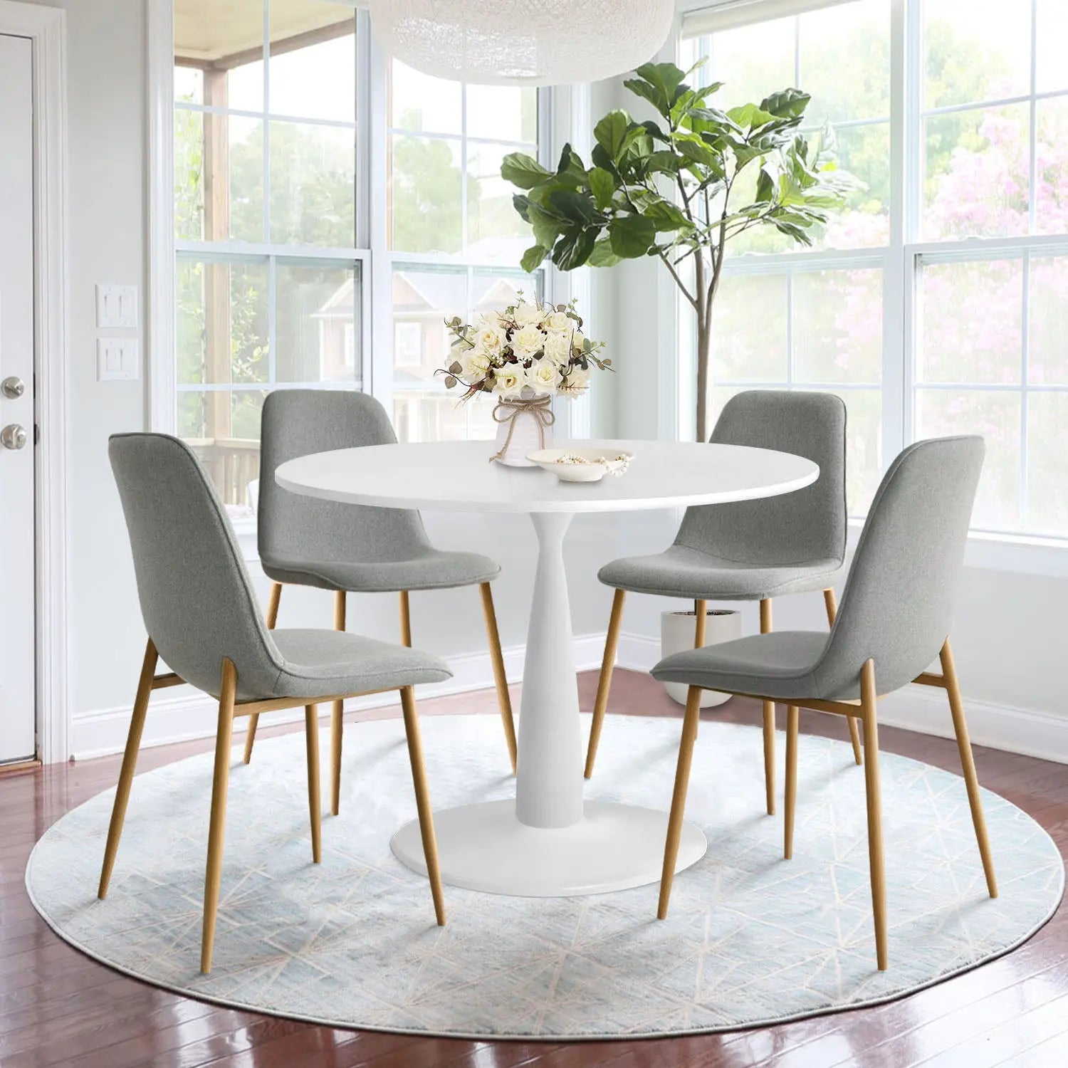 Haven & Oslo dining set with white table, grey chairs on round rug in bright dining room.